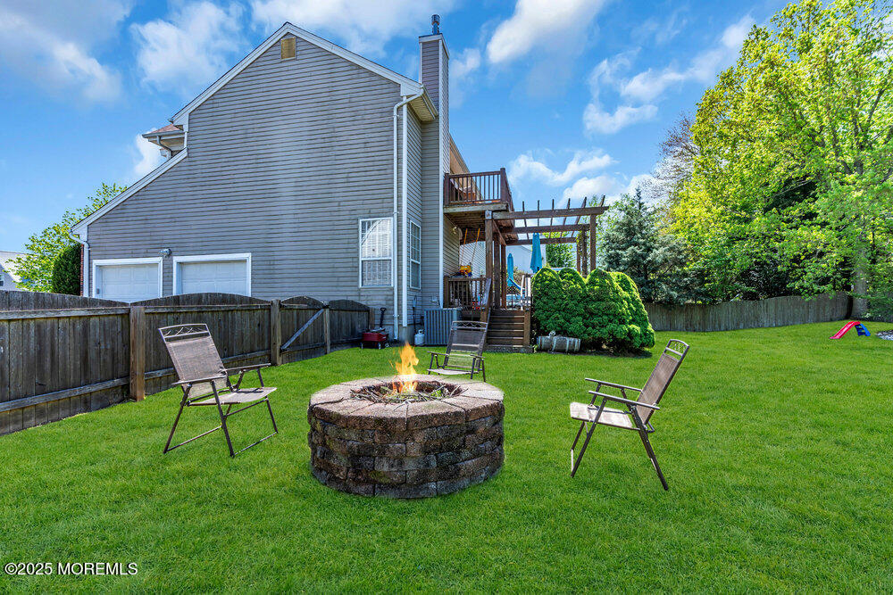 41 Hampshire Boulevard Jackson, NJ 08527 - Photo 37 of 55 a view of a backyard with table and chairs with a fire pit and a small yard