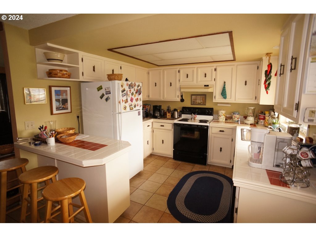 5637 E Street Springfield, OR 97478 - Photo 9 of 27 a kitchen with stainless steel appliances granite countertop a sink a stove a refrigerator and a refrigerator
