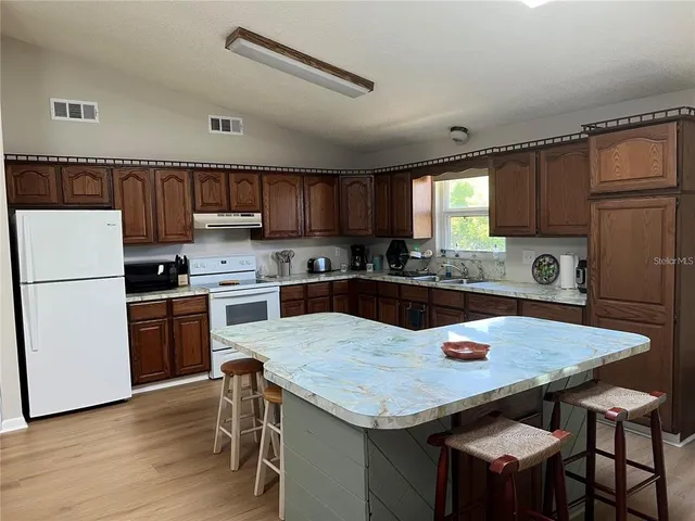 a kitchen with a stove a refrigerator and a dining table