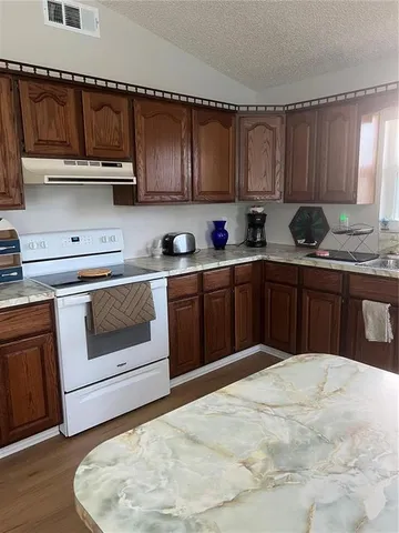 a kitchen with stainless steel appliances granite countertop a stove a sink dishwasher and a microwave oven on the table