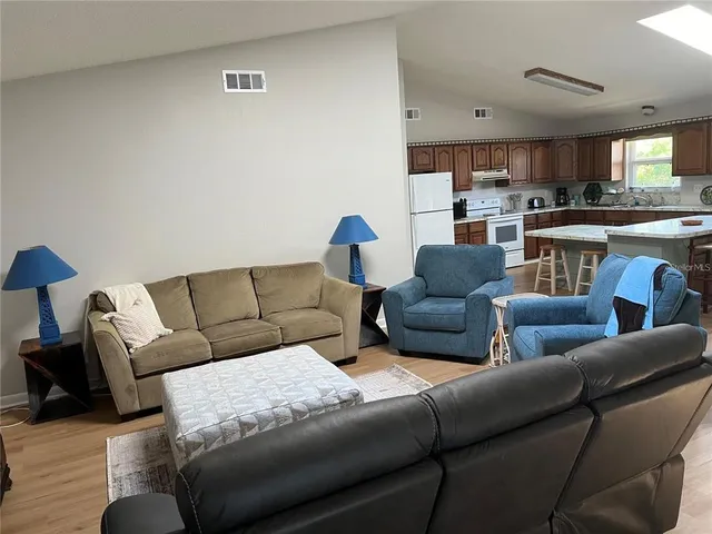 a living room with furniture and a view of kitchen