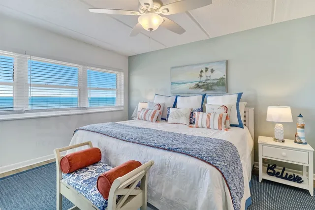 a bed sitting in a spacious bedroom next to a window