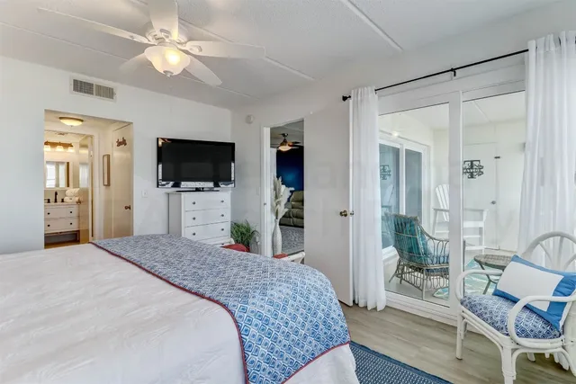 a spacious bedroom with a bed and a flat screen tv