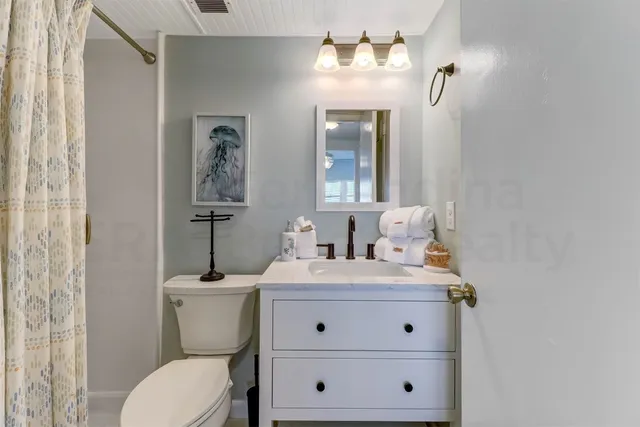 a white toilet sitting next to a shower