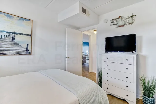a view of bedroom with furniture and flat screen tv