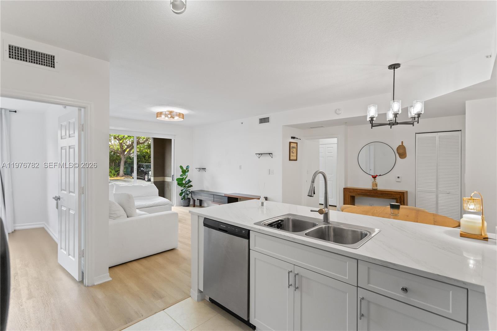 6851 Southwest 44th Street, Unit 107 Miami, FL 33155 - Photo 12 of 41 a kitchen with stainless steel appliances a sink a counter space and chandelier