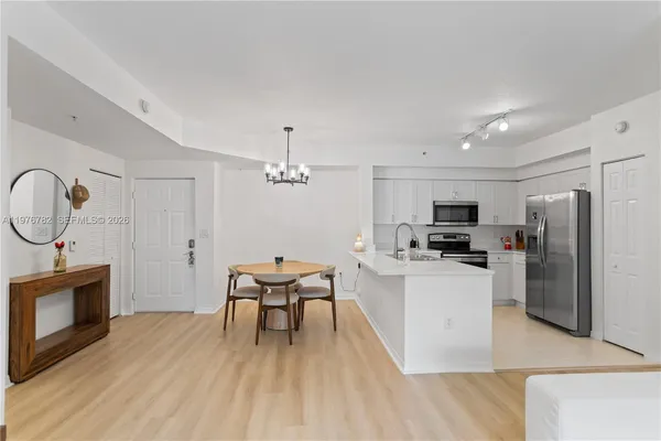 a kitchen with stainless steel appliances a refrigerator sink and white cabinets