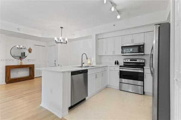 a kitchen with stainless steel appliances a refrigerator sink and microwave