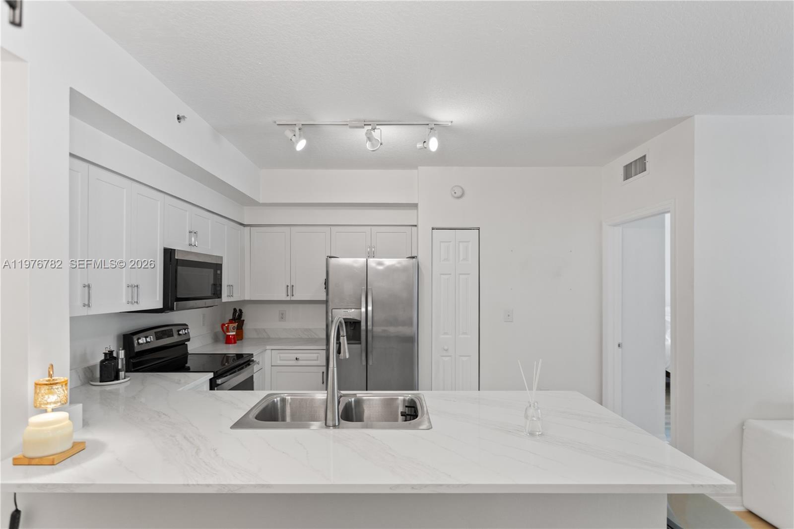 6851 Southwest 44th Street, Unit 107 Miami, FL 33155 - Photo 16 of 41 a kitchen with stainless steel appliances a refrigerator sink and microwave