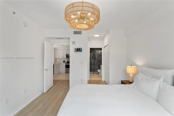 a bedroom with a bed and a chandelier
