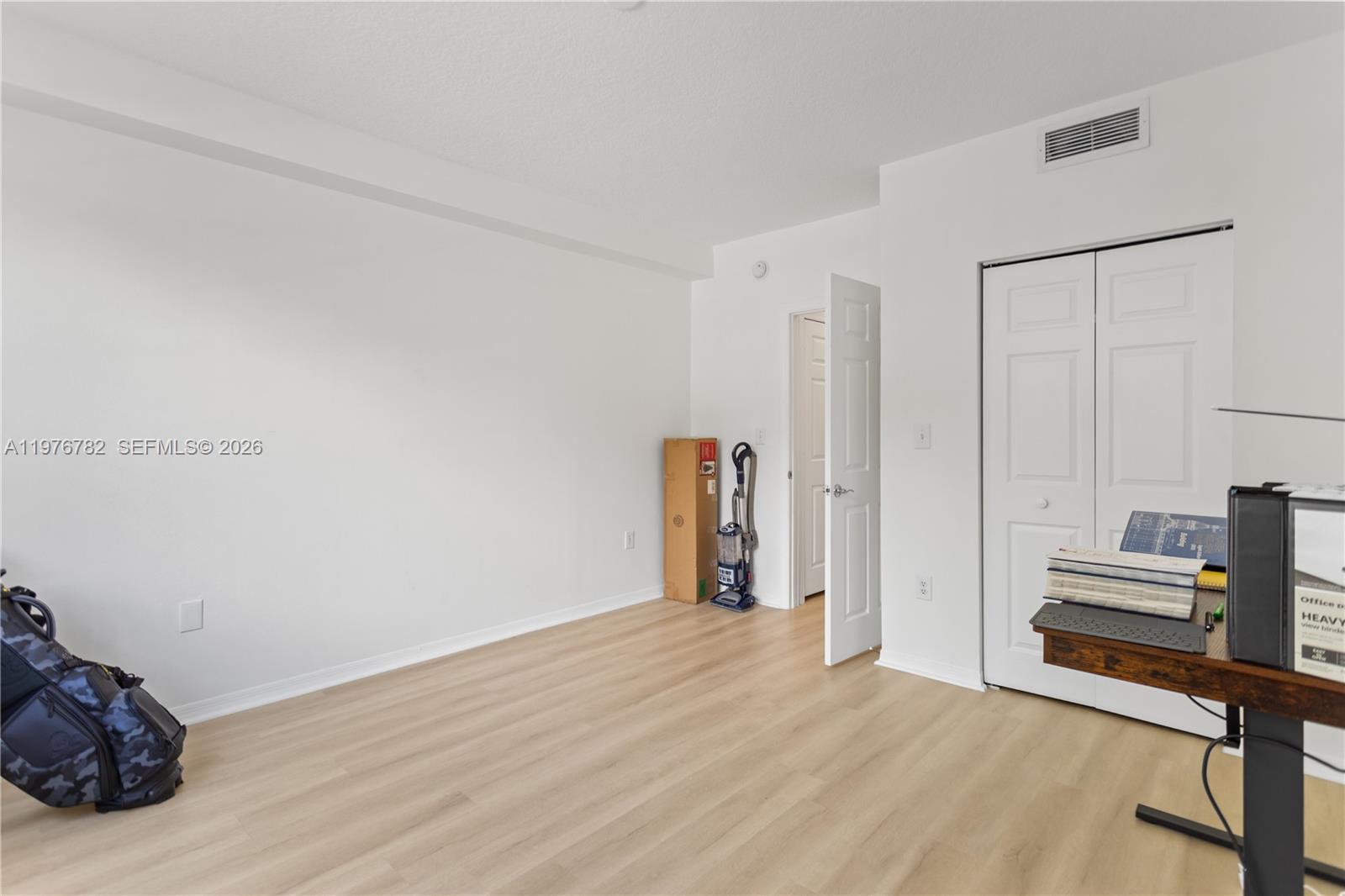 6851 Southwest 44th Street, Unit 107 Miami, FL 33155 - Photo 25 of 41 a view of an empty room with wooden floor and closet