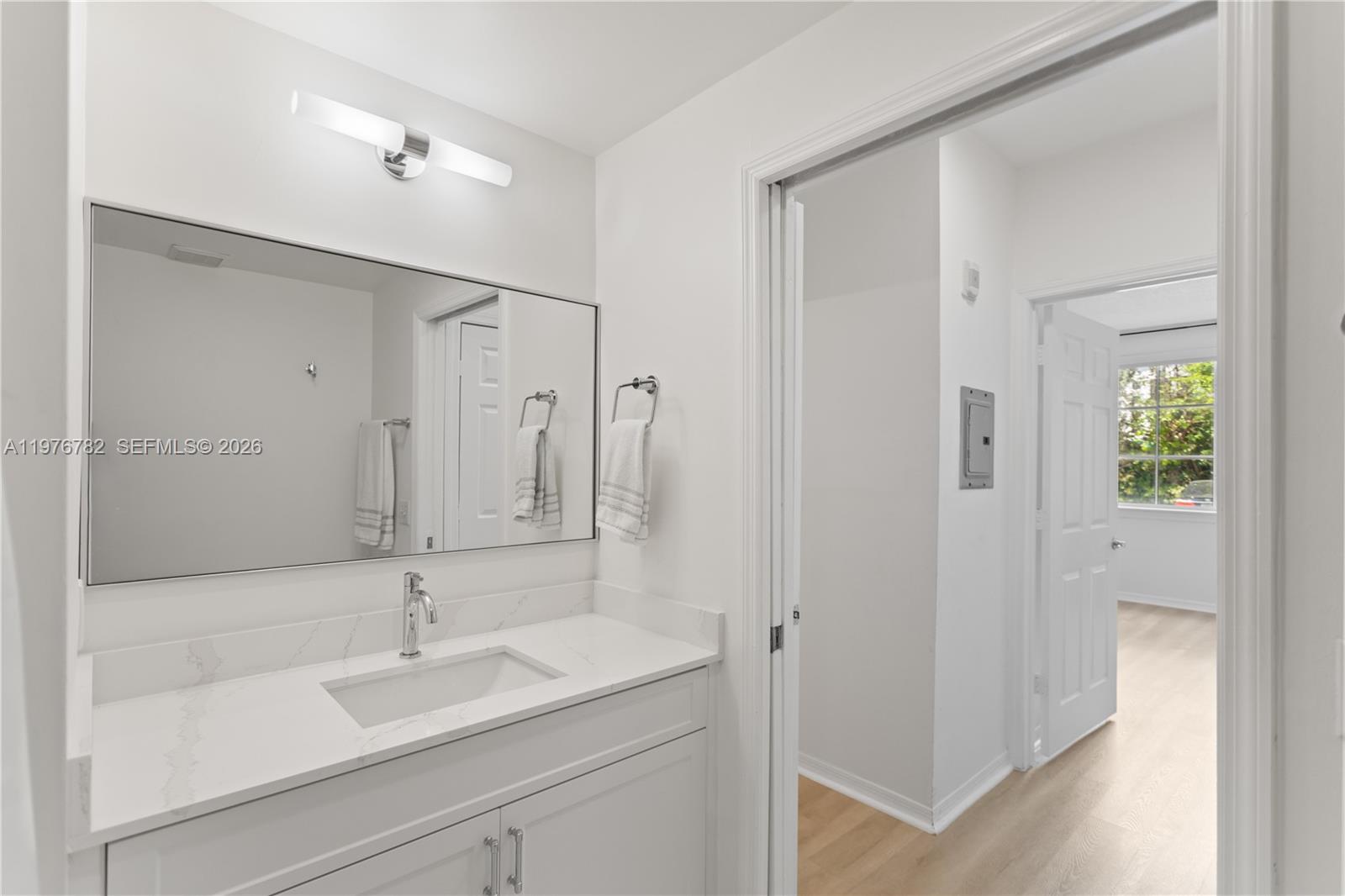 6851 Southwest 44th Street, Unit 107 Miami, FL 33155 - Photo 27 of 41 a bathroom with a granite countertop sink a mirror and a shower