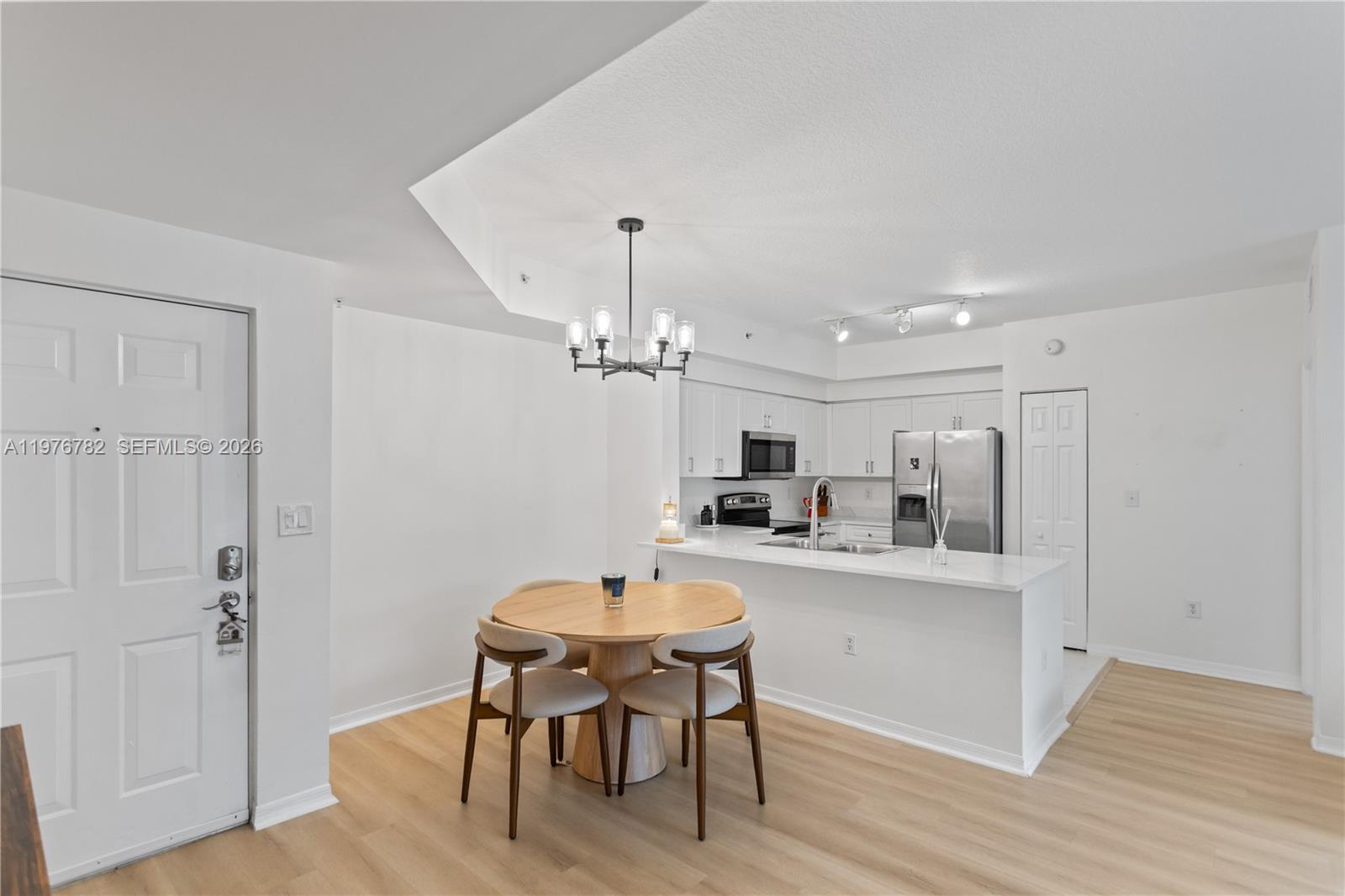 6851 Southwest 44th Street, Unit 107 Miami, FL 33155 - Photo 29 of 41 a kitchen with kitchen island a dining table chairs cabinets and stainless steel appliances