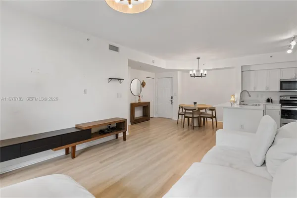 a living room with furniture and a wooden floor