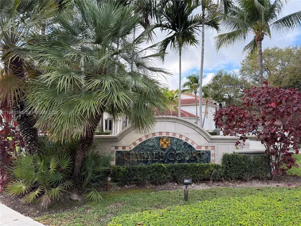 front view of a house with a yard and palm trees