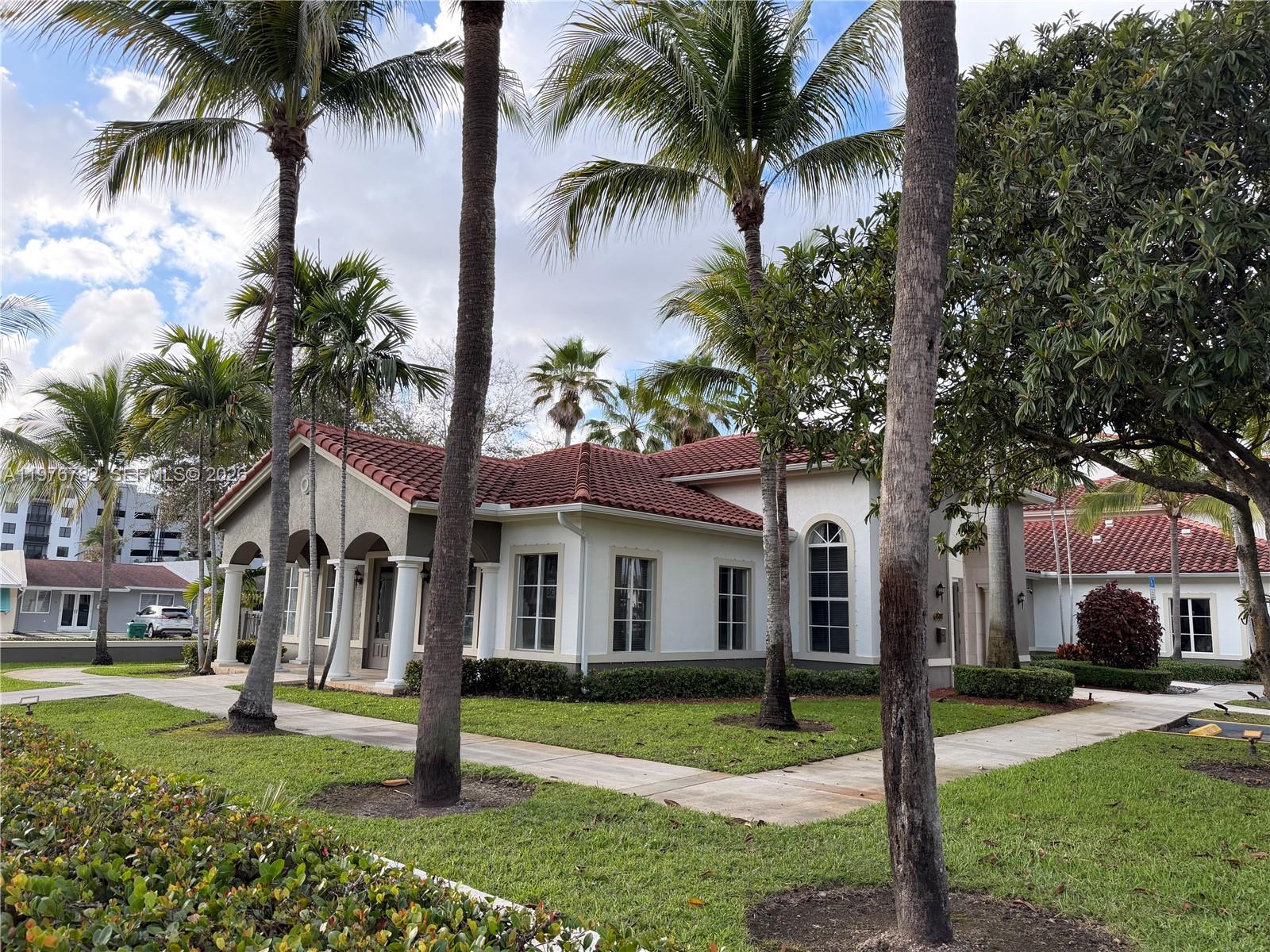 6851 Southwest 44th Street, Unit 107 Miami, FL 33155 - Photo 38 of 41 front view of a house with a yard and palm trees