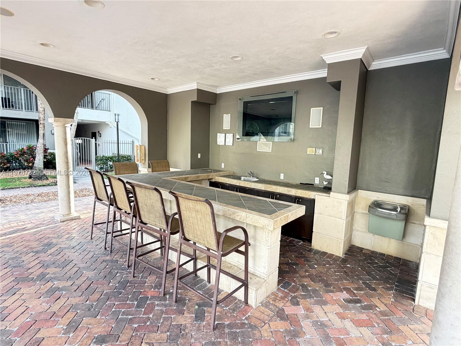 6851 Southwest 44th Street, Unit 107 Miami, FL 33155 - Photo 40 of 41 a living room with chairs and a flat screen tv