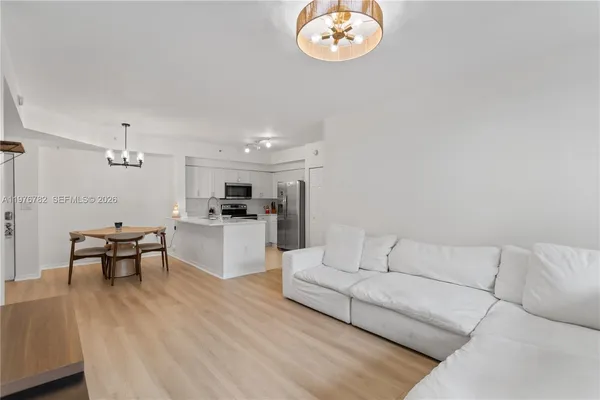 a view of a dining room with furniture a chandelier and wooden floor