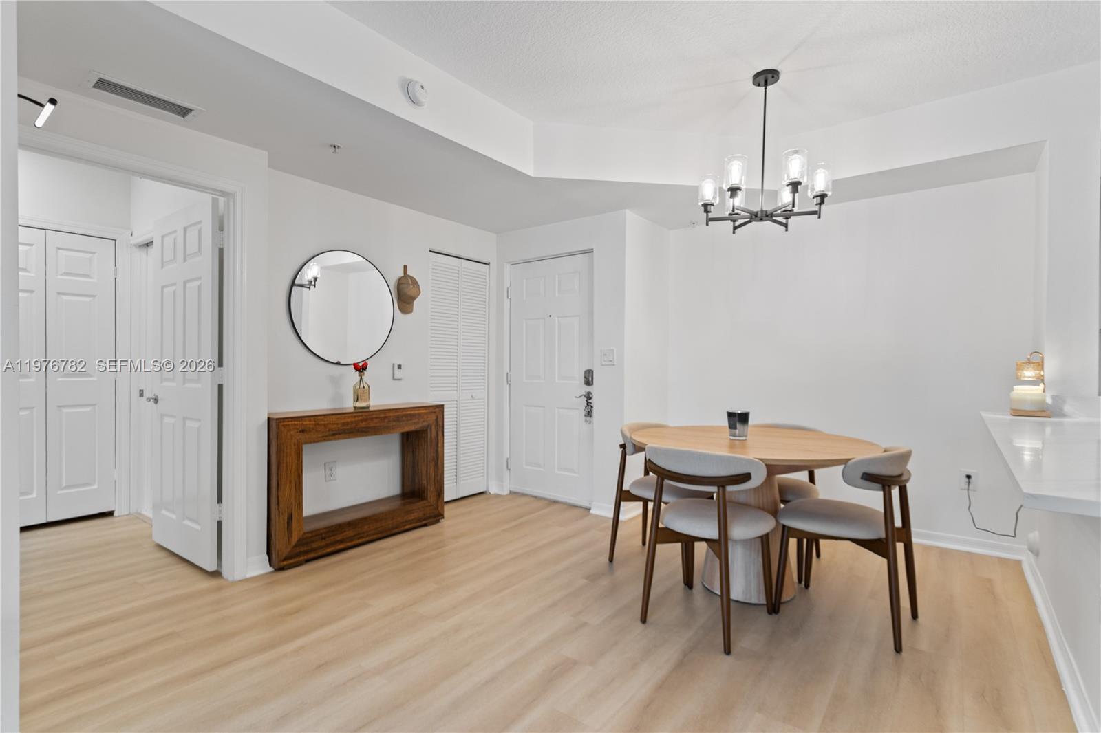 6851 Southwest 44th Street, Unit 107 Miami, FL 33155 - Photo 10 of 41 a view of a dining room with furniture a chandelier and wooden floor