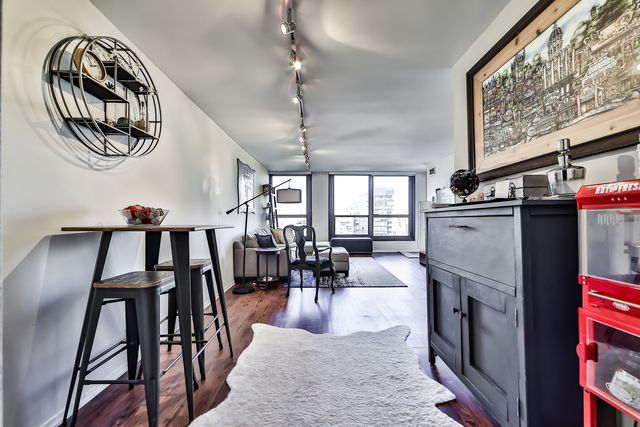 1030 North State Street, Unit 20D Chicago, IL 60610 - Photo 11 of 22 an open kitchen with a dining table chairs and a chandelier
