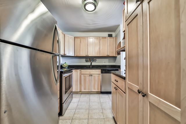 1030 North State Street, Unit 20D Chicago, IL 60610 - Photo 7 of 22 a kitchen with stainless steel appliances granite countertop a refrigerator a sink and white cabinets