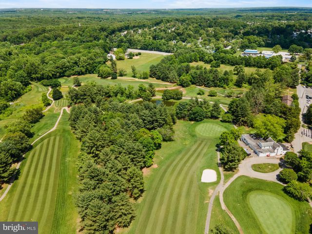 a sign of golf club on a wall under a tree