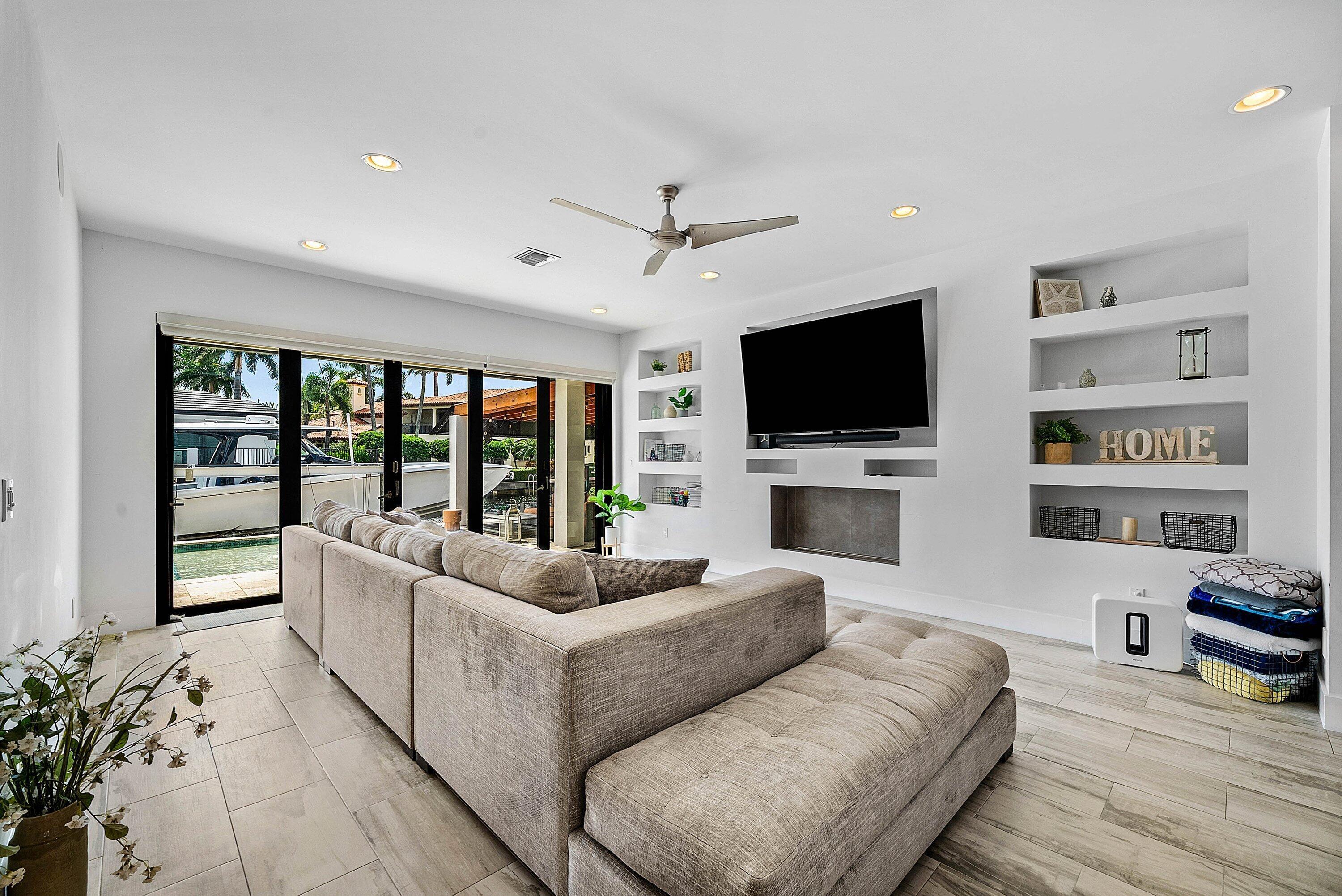 740 Northeast 36th Street Boca Raton, FL 33431 - Photo 12 of 43 a living room with furniture flat screen tv and a fireplace