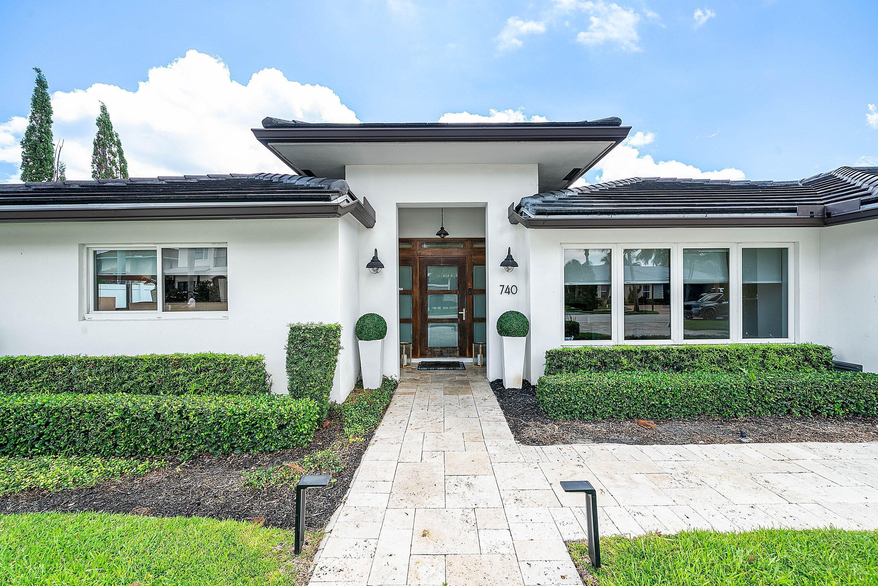 740 Northeast 36th Street Boca Raton, FL 33431 - Photo 3 of 43 a front view of a house with garden