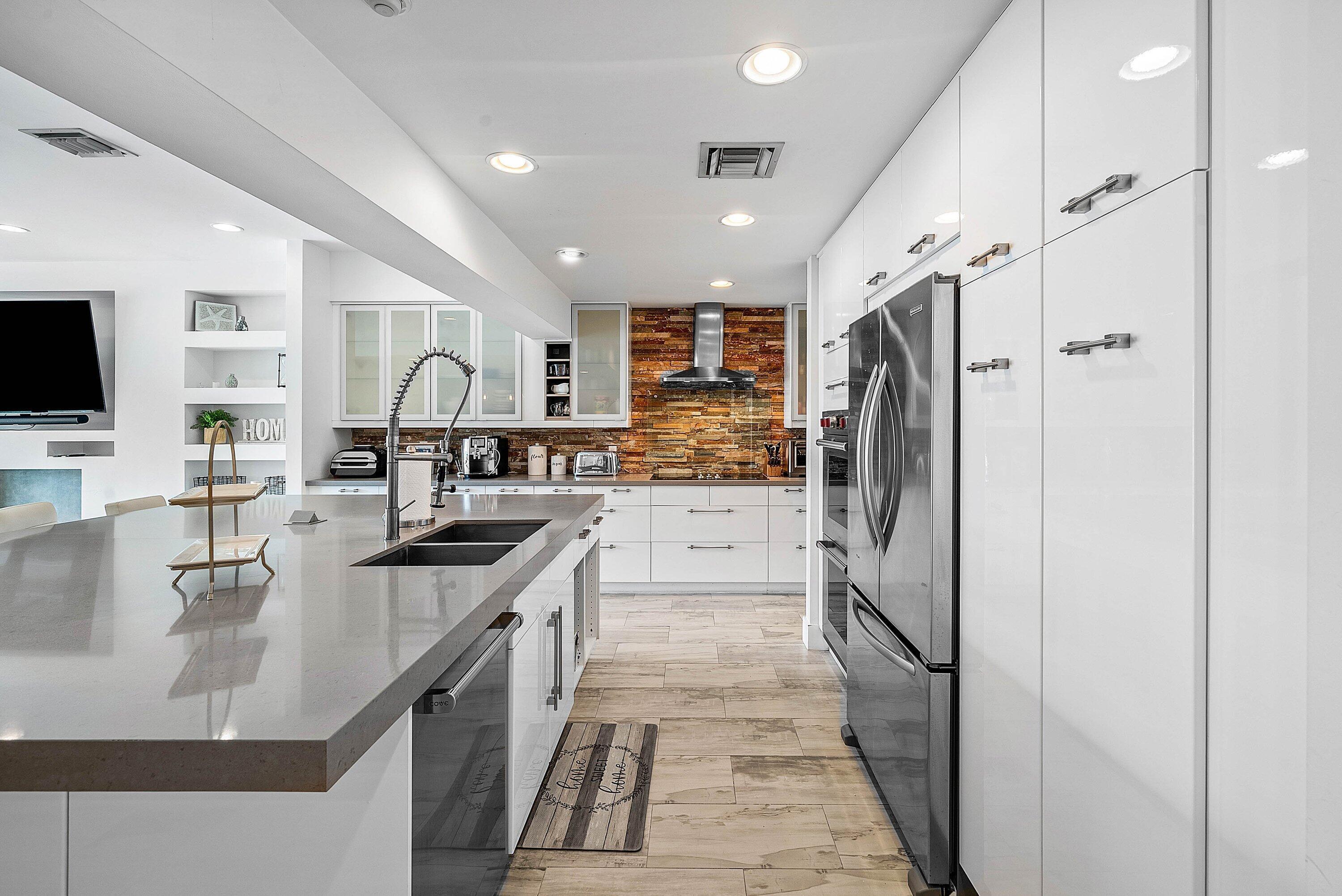 740 Northeast 36th Street Boca Raton, FL 33431 - Photo 8 of 43 a kitchen with stainless steel appliances granite countertop a refrigerator a oven a sink a stove and white cabinets with wooden floor
