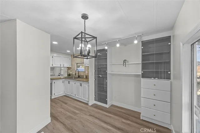 a kitchen with a refrigerator and white cabinets
