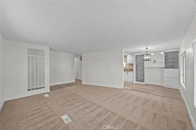 a view of a big room with wooden floor and windows