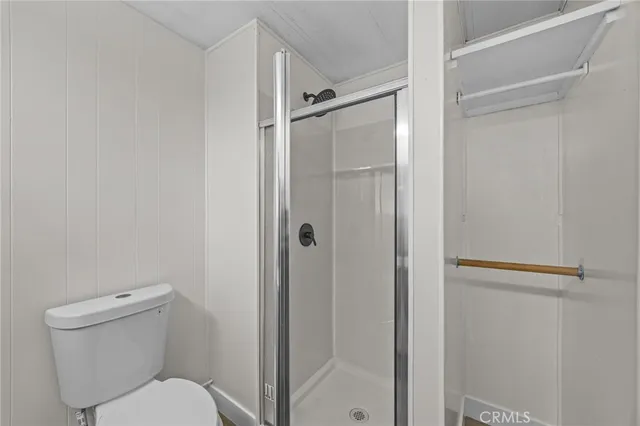 a white toilet sitting next to a shower