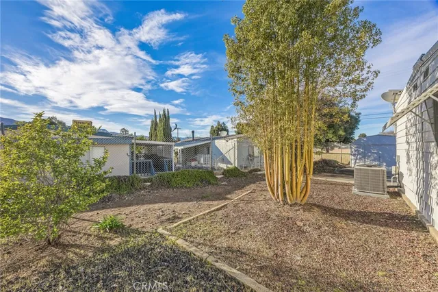 a front view of a house with a garden and trees