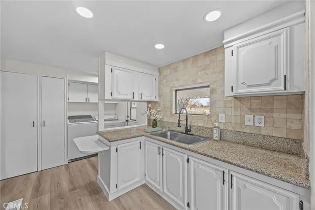 a kitchen with white cabinets and sink