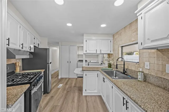 a kitchen with stainless steel appliances granite countertop a sink stove and refrigerator