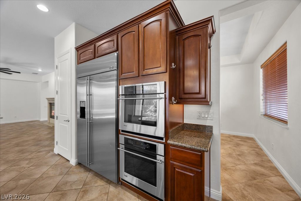 2125 De Rouge Avenue Henderson, NV 89044 - Photo 42 of 96 Culinary adventures await in this kitchen, boasting rich wood cabinetry, granite counters, and stainless steel appliances.
