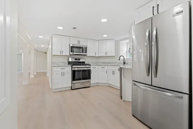 a kitchen with stainless steel appliances a refrigerator and a stove top oven