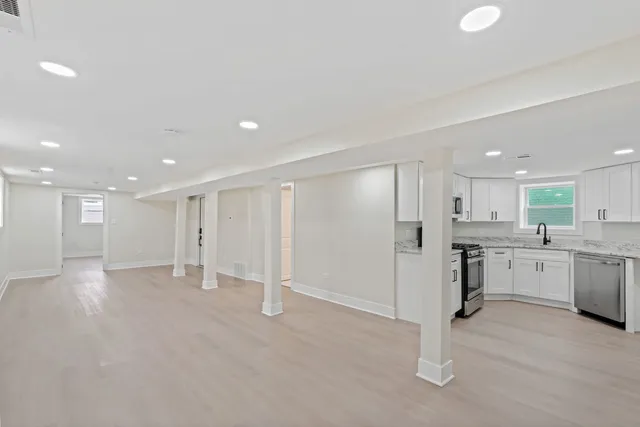 an empty room with wooden floor and window