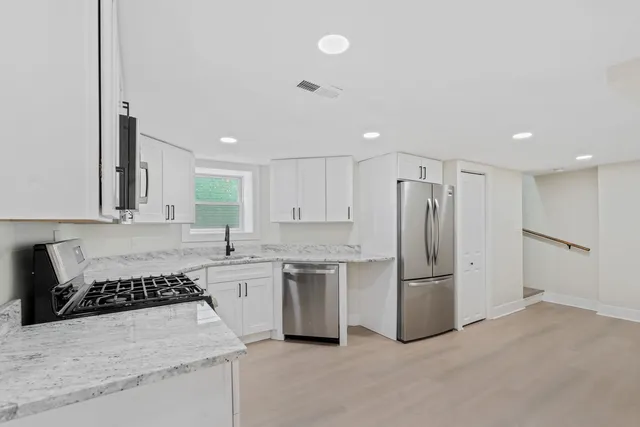 a kitchen with stainless steel appliances a refrigerator sink and microwave
