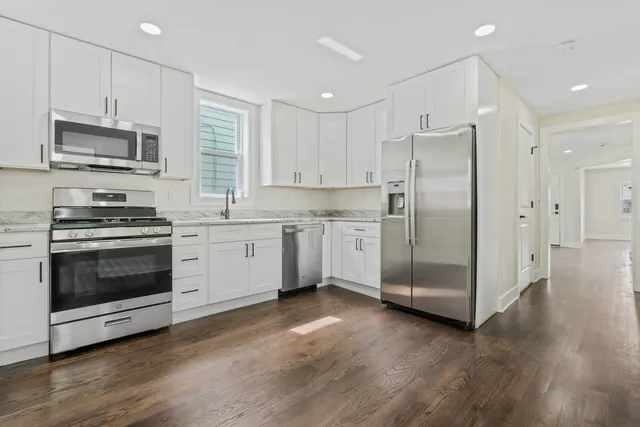 a bathroom with a granite countertop sink a toilet and shower