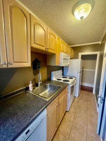 a kitchen with a stove a sink and a window
