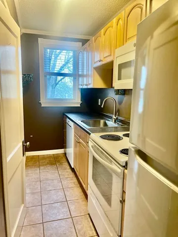 a kitchen with stainless steel appliances granite countertop a sink a stove a refrigerator with grey cabinets