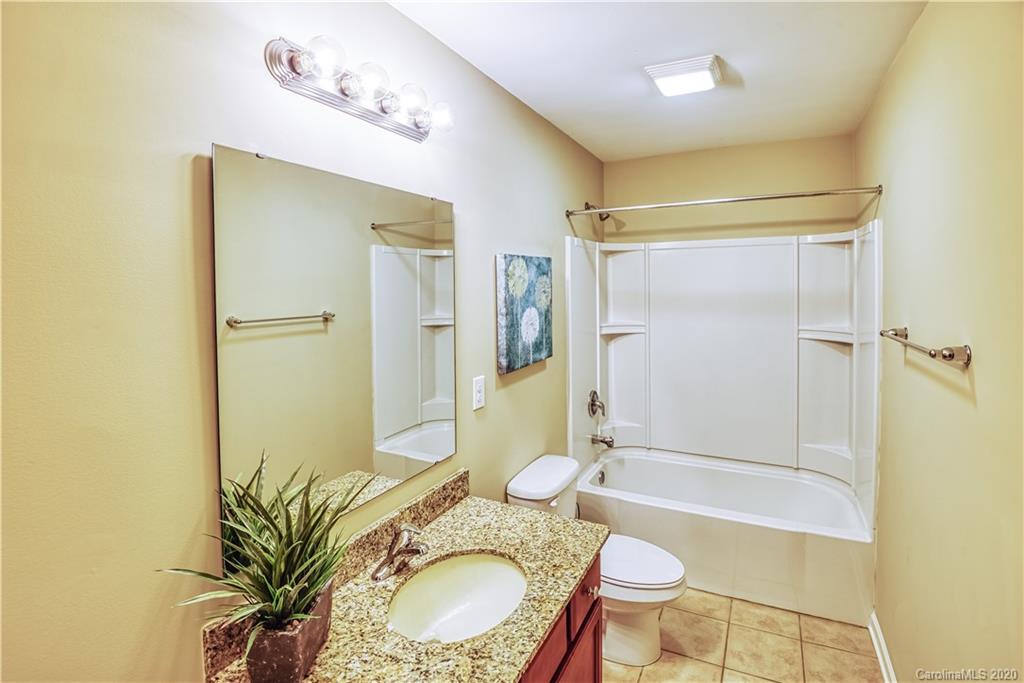 2156 Bluebell Way Tega Cay, SC 29708 - Photo 22 of 30 a bathroom with a granite countertop sink toilet mirror vanity and shower