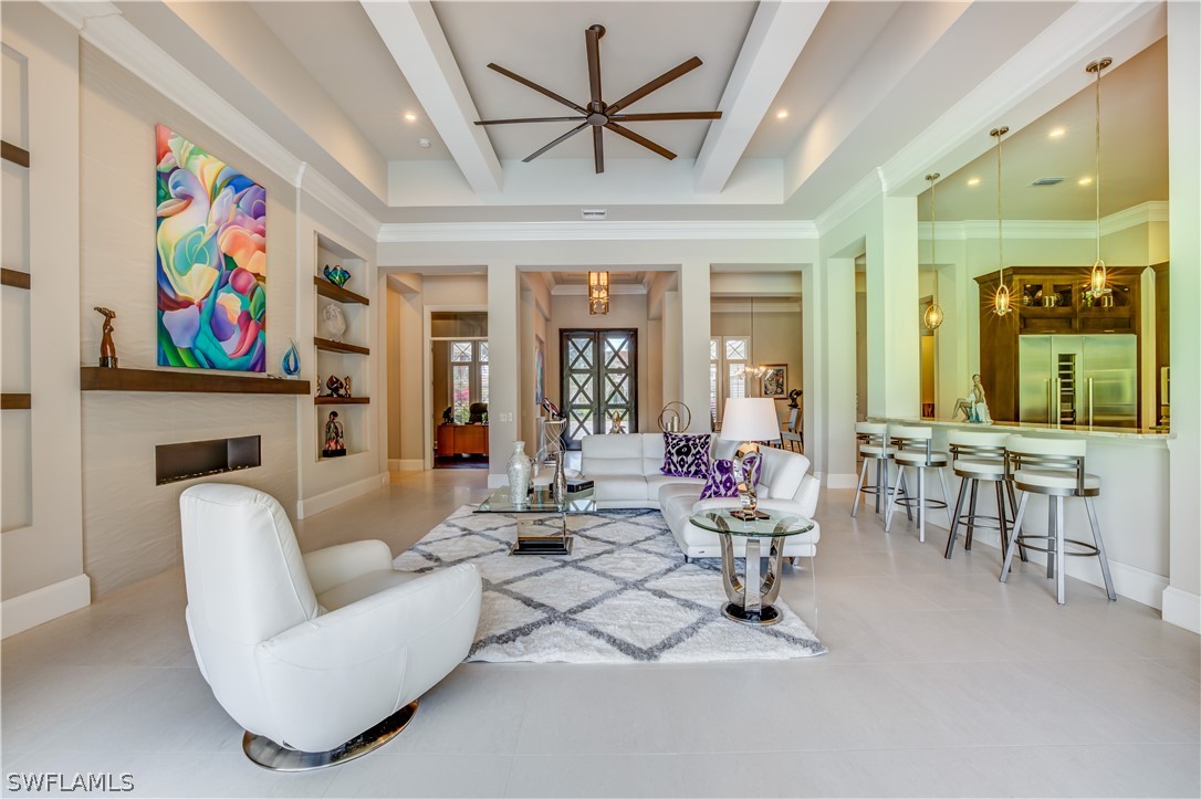 4257 Deephaven Lane Naples, FL 34119 - Photo 11 of 13 a living room with furniture a fireplace and a chandelier