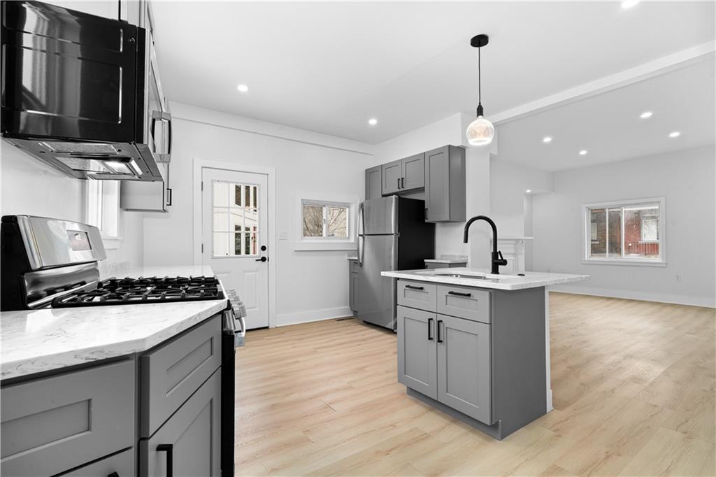 309 North Mathilda Street Pittsburgh, PA 15224 - Photo 9 of 30 a kitchen with stainless steel appliances granite countertop a sink stove and refrigerator