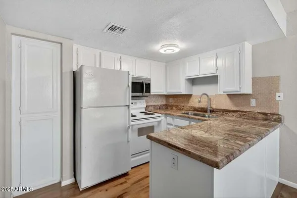 a kitchen with a refrigerator a sink and wooden cabinets