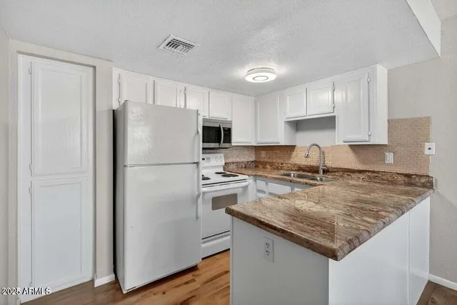 a kitchen with a refrigerator a sink and wooden cabinets