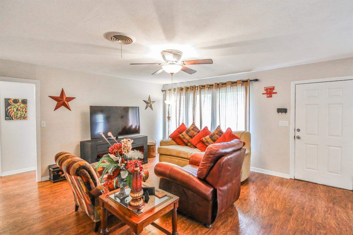 3408 38th Street Lubbock, TX 79413 - Photo 5 of 10 a living room with furniture a flat screen tv and a window