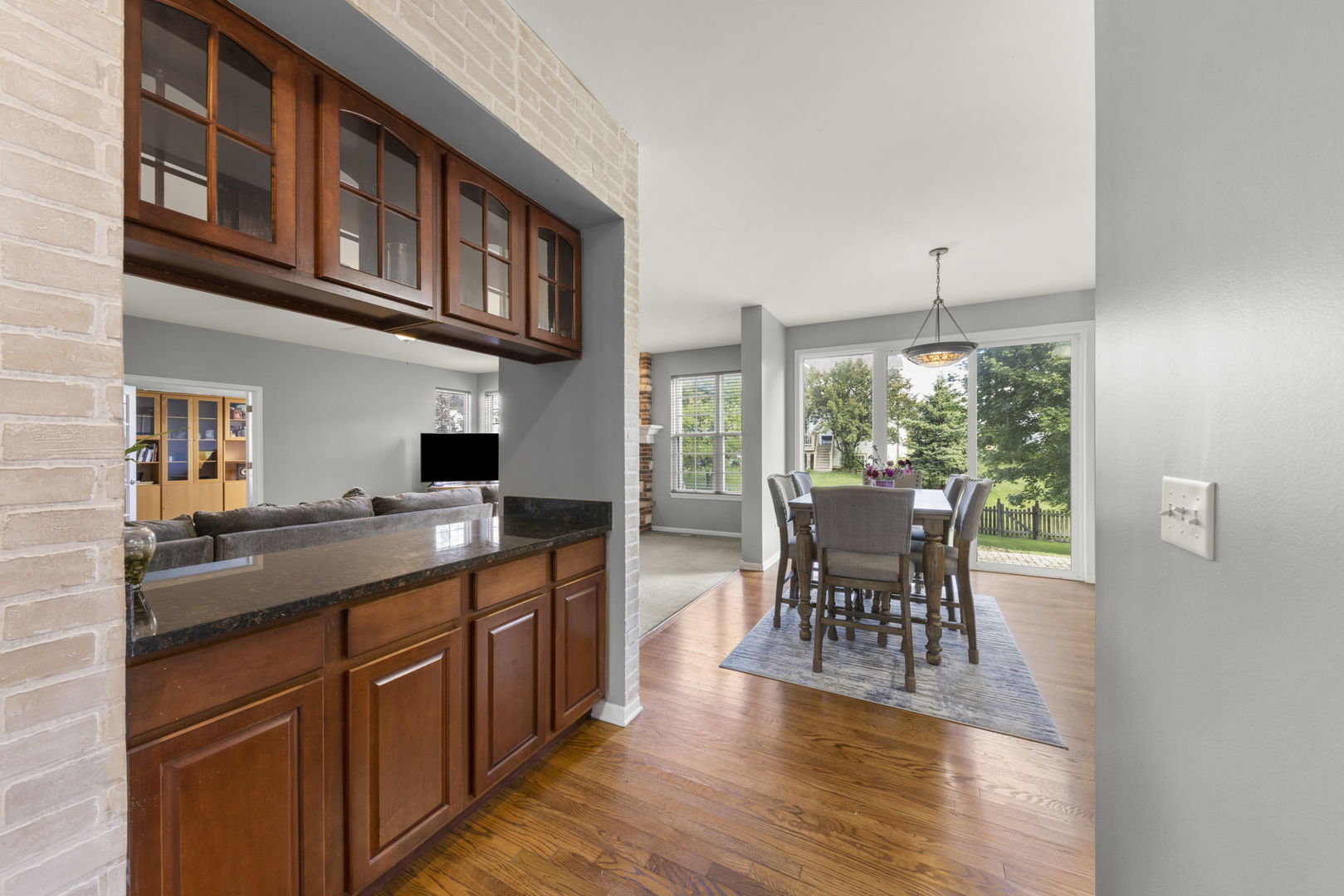 26210 Mapleview Drive Plainfield, IL 60585 - Photo 8 of 55 a kitchen with stainless steel appliances granite countertop a stove top oven a sink a dining table and chairs with wooden floor