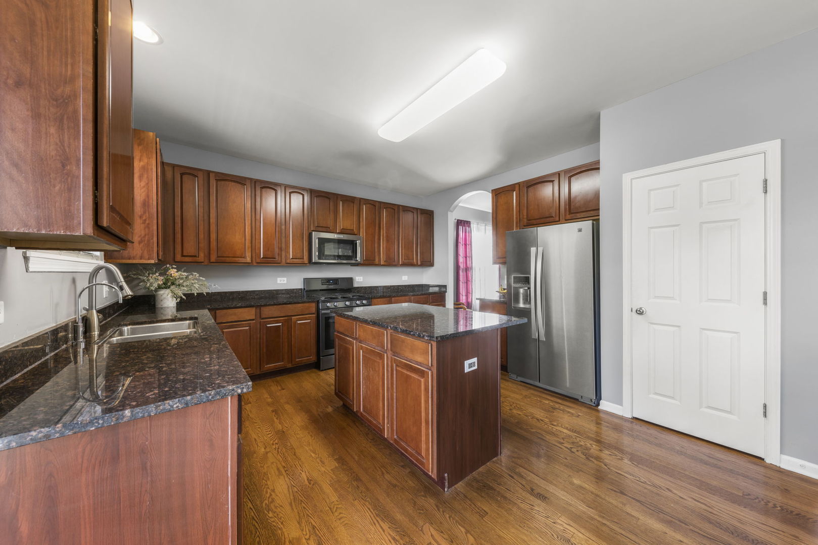 26210 Mapleview Drive Plainfield, IL 60585 - Photo 10 of 55 a kitchen with stainless steel appliances granite countertop a stove a refrigerator a sink dishwasher and wooden cabinets with wooden floor